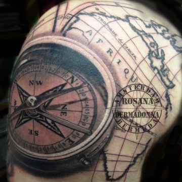 Map pf Africa and Compass Black and Grey Realism tattoo done on upper arm